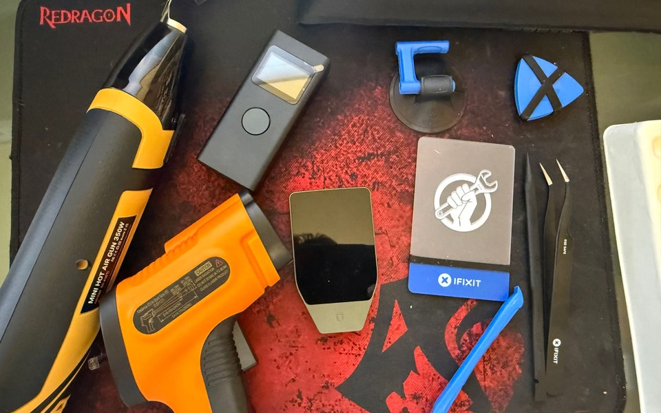 Hardware wallets beside opening tools, tweezers and a heat gun